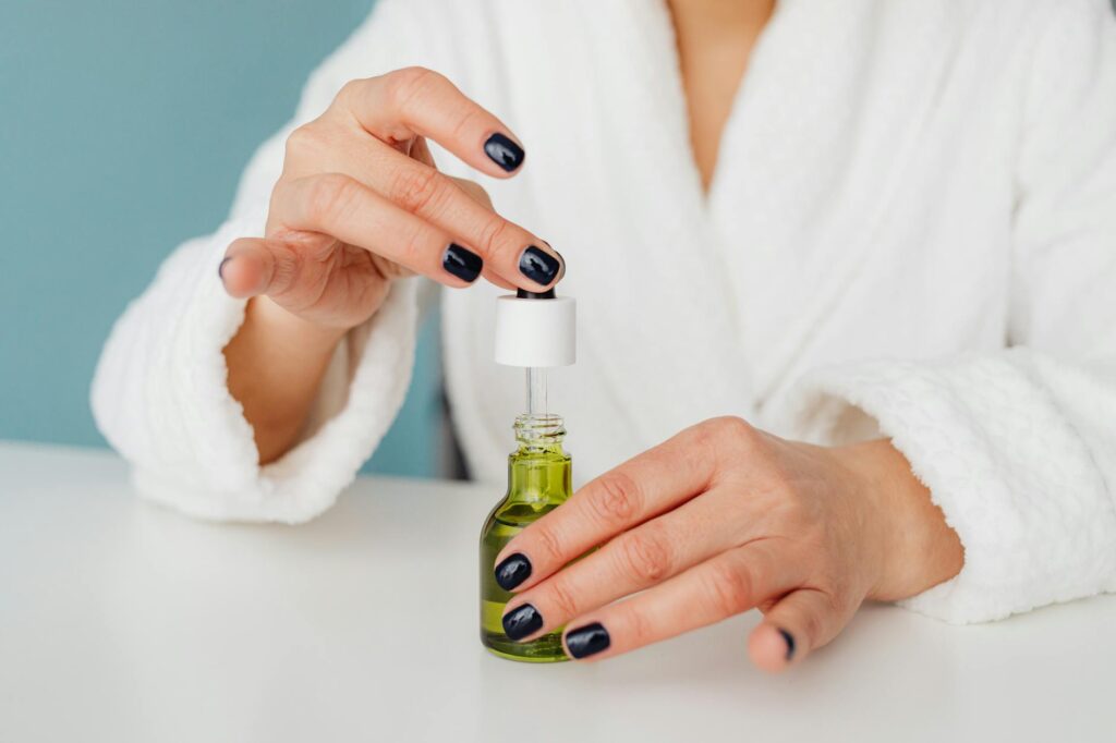 hands of woman opening bottle of body oil